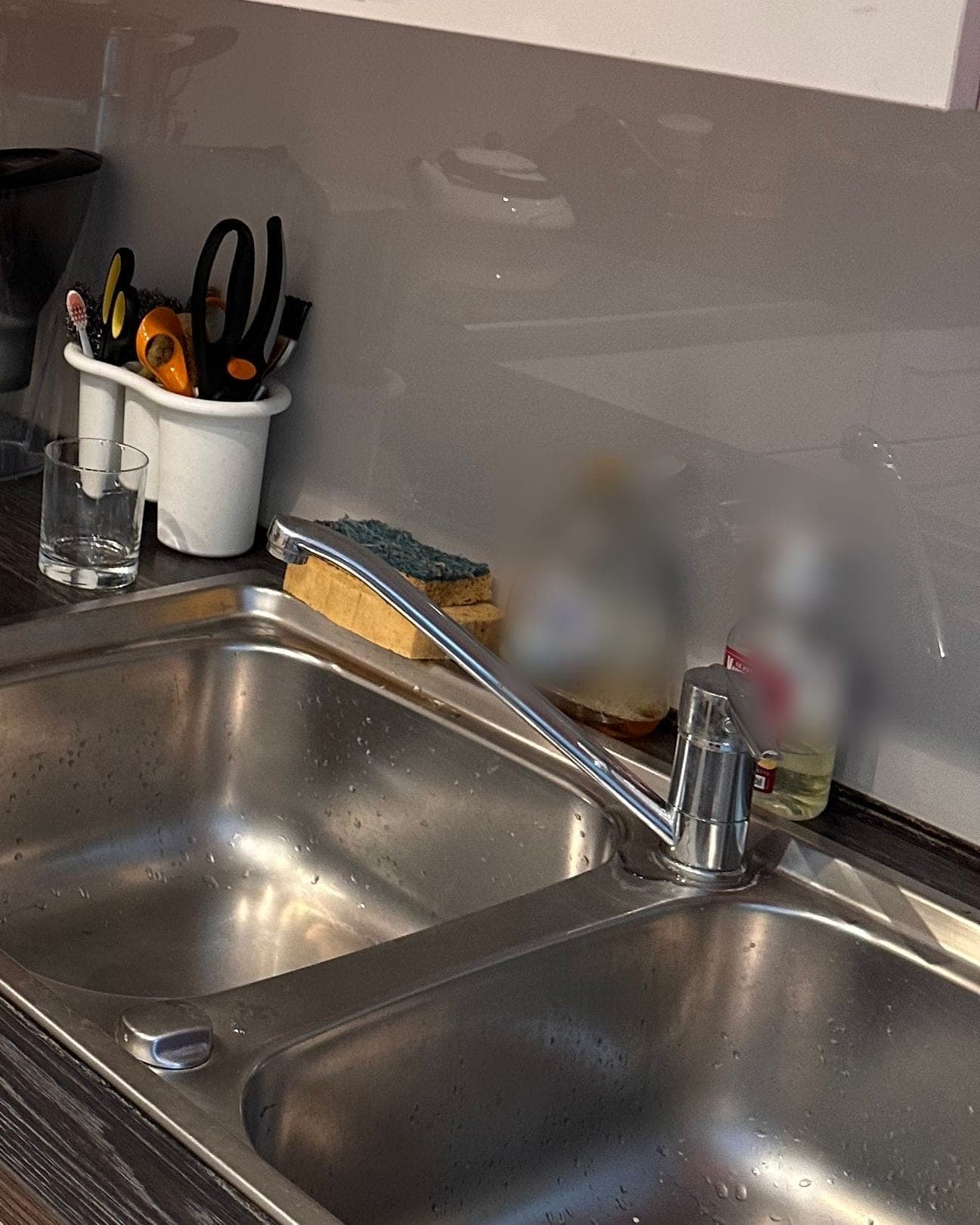 Double évier en inox vide, plan de travail dégagé et placards hauts refermés